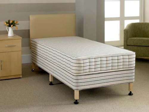 A bed with six legs and a cream headboard.